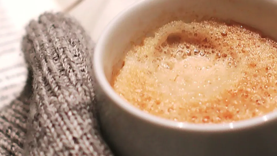 Tazzina di caffè con foglie rosse autunnali